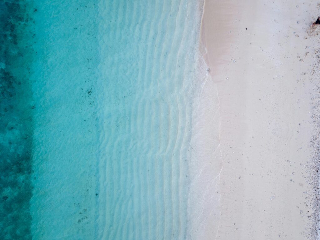 Aerial photo of a pink beach with crystal clear water in the Coral Triangle.
